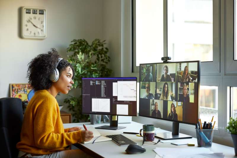 Young woman on a digital call with her coworkers working from a home office