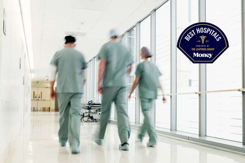 Three doctors walk hastily through a hospital