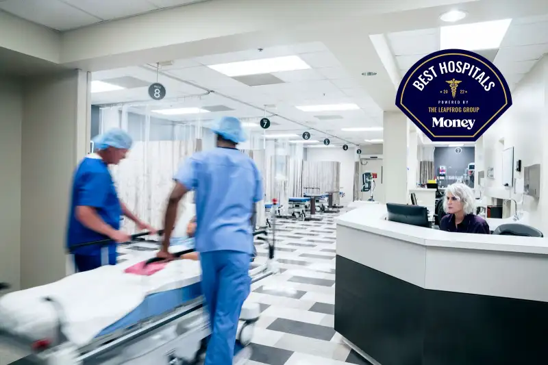 Two doctors push a gurney with a patient through and emergency room at a hospital