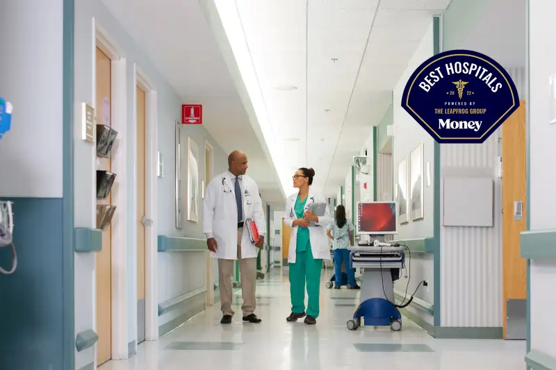 Two doctors talking while walking through a hospital hallway