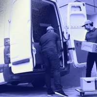 Photo of two men moving boxes and furniture