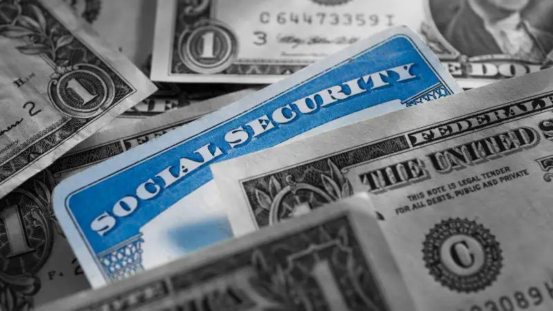 Photo of a social security card surrounded by money bills