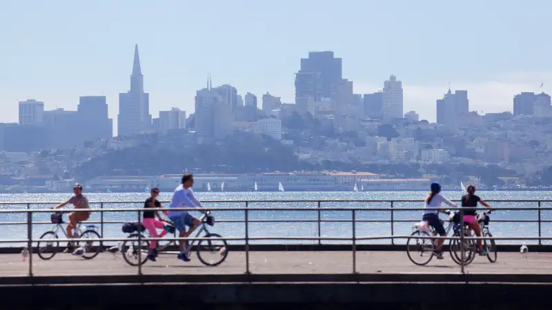 Photo of a family biking alongside the San Francisco skyline