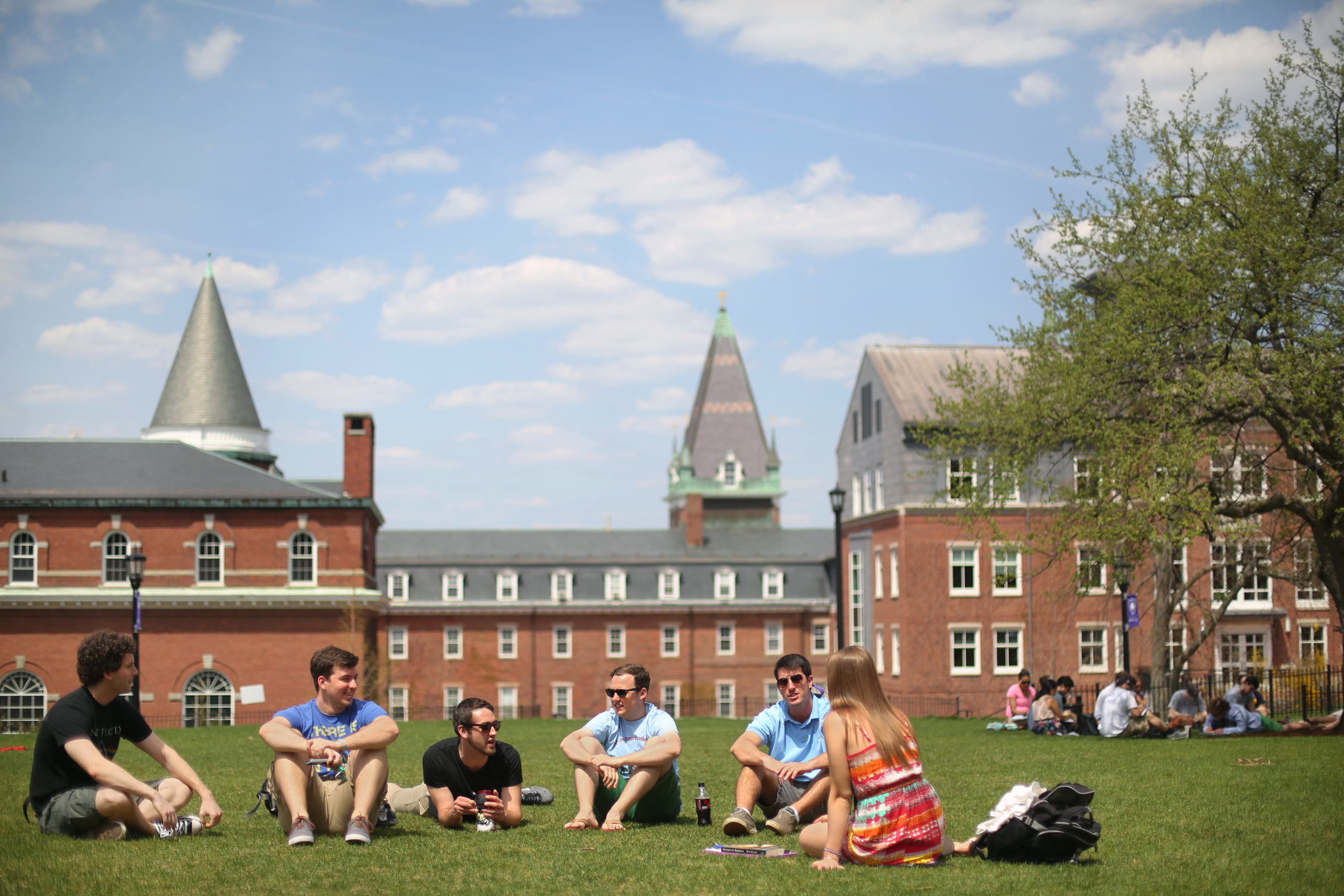 Students sitting on the lawn at the College of the Holy Cross campus