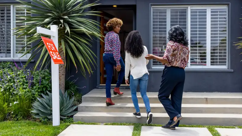 Real-estate agent showing a home for sale to a mother and daughter