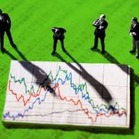 Photo collage of businessmen figurines looking at a stock market chart