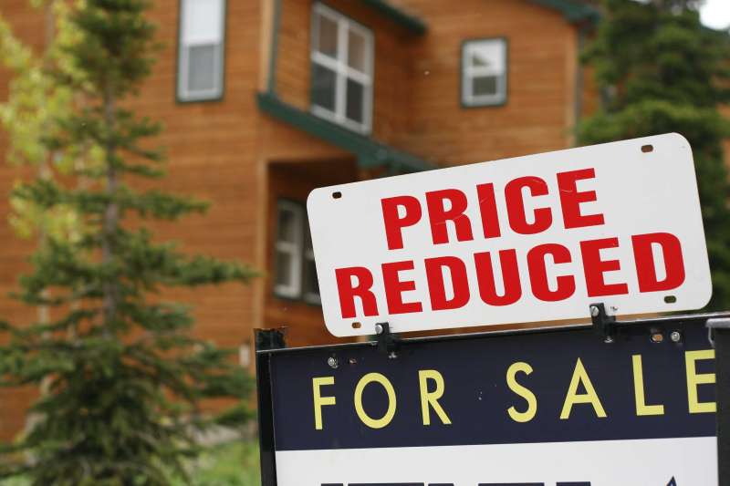 A Price Reduced For Sale Sign In Front Of A House