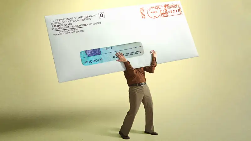 Photo collage of a person holding a giant envelope from the IRS containing a Stimulus Check