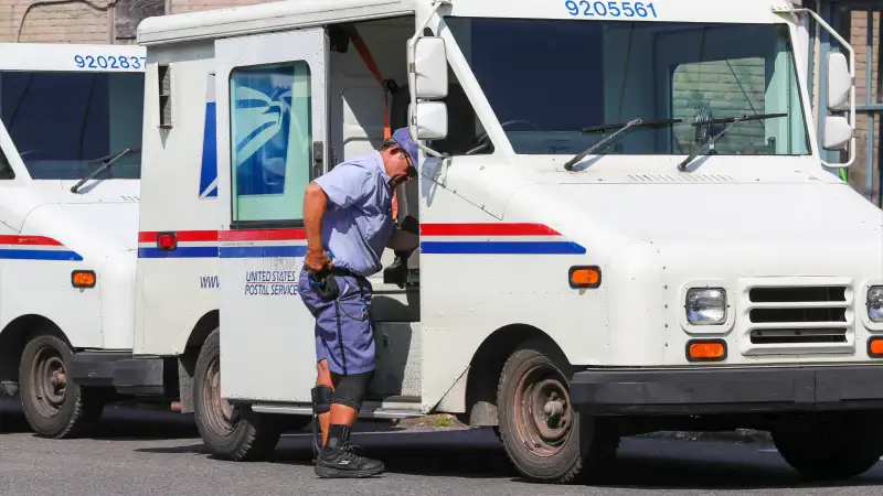 Post worker alongside USPS truck