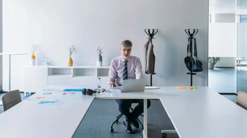 Senior man working alone in an office conference room