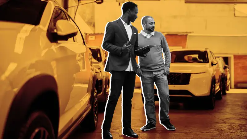 Salesman showing car to customer in a car dealership