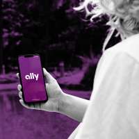 Close-up of a person holding a smartphone with the Ally bank app
