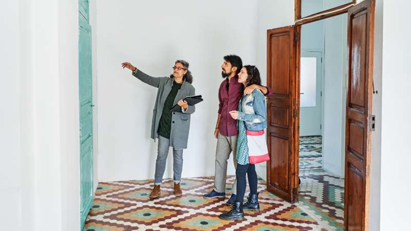 Couple and real estate agent examining rental options