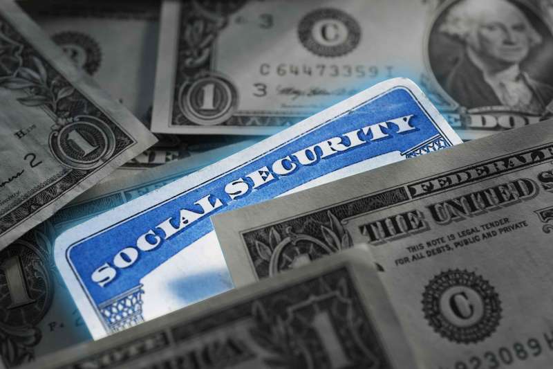 Social Security Card Inside A Pile Of Dollar Bills