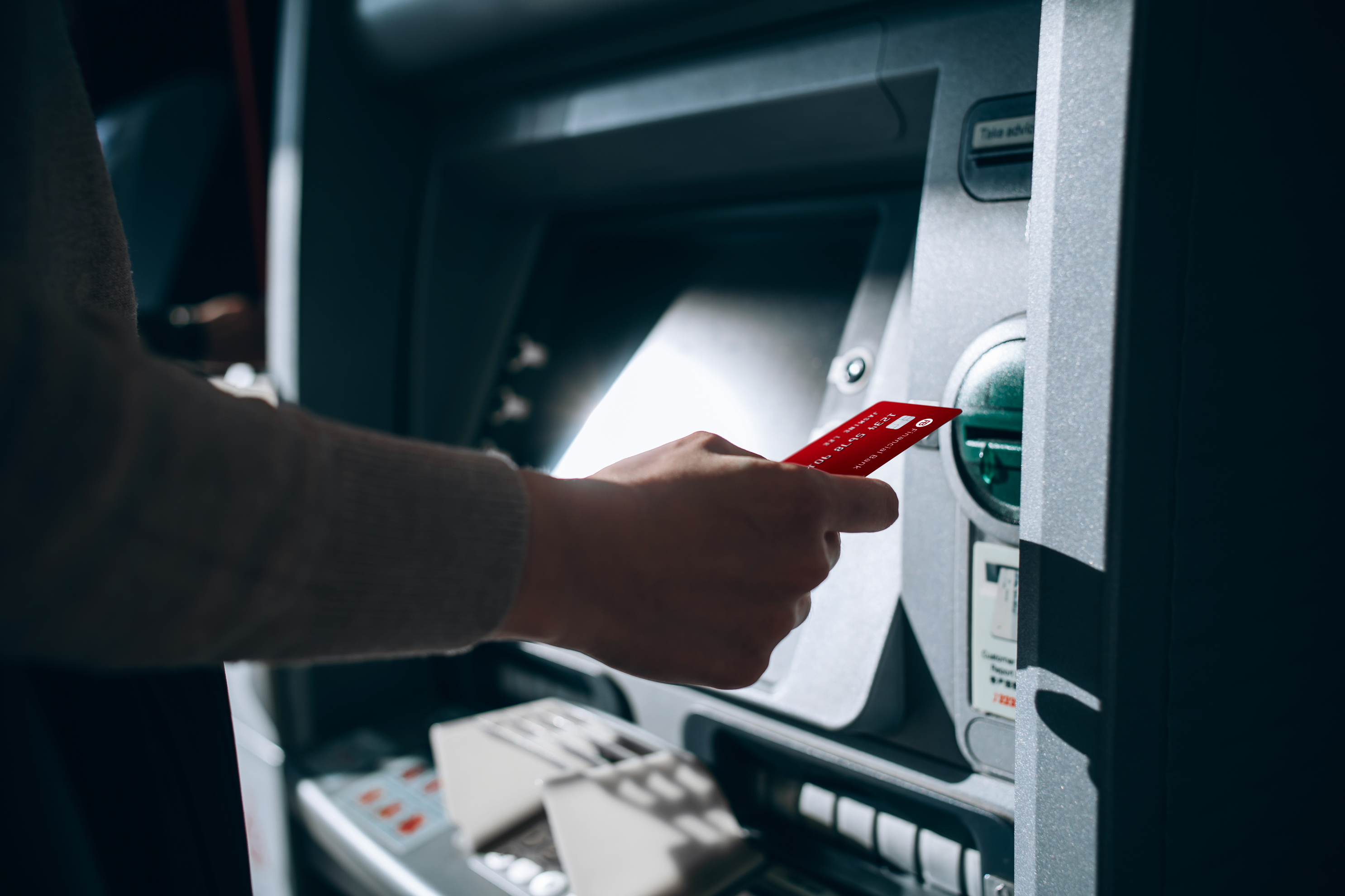 Person inserting a debit card into a ATM machine