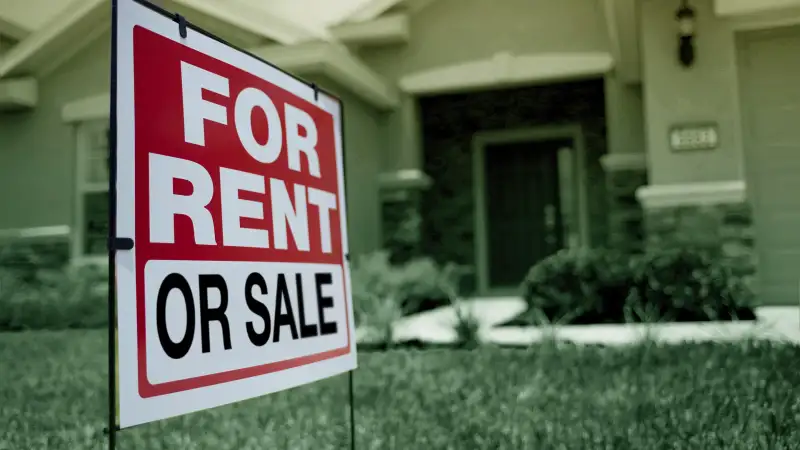 House with a sign that indicates it's for sale or for rent