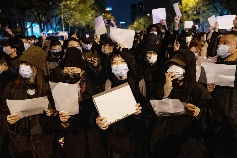 Demonstrators hold white signs as a form of protest during a protest against Zero Covid and epidemic prevention restrictions in Beijing, China, on Sunday, November 27, 2022