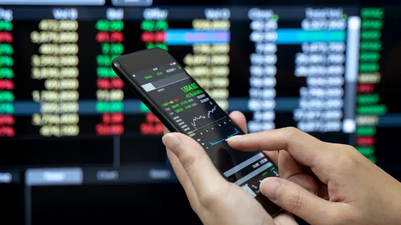 Businessman checking stock market on mobile phone