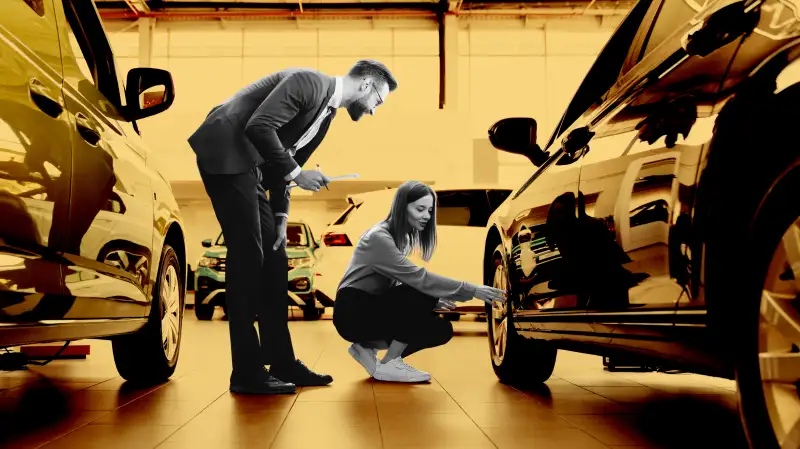 Woman inspecting a new car at car dealership