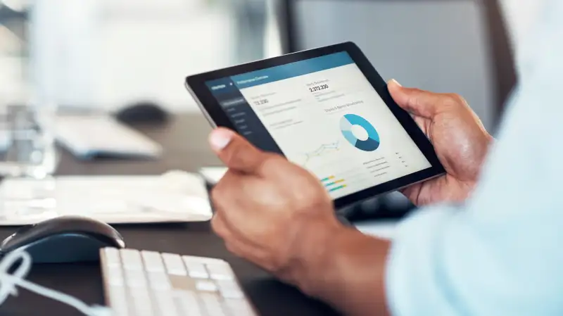 Close-up of a man using a smart tablet to use a management software