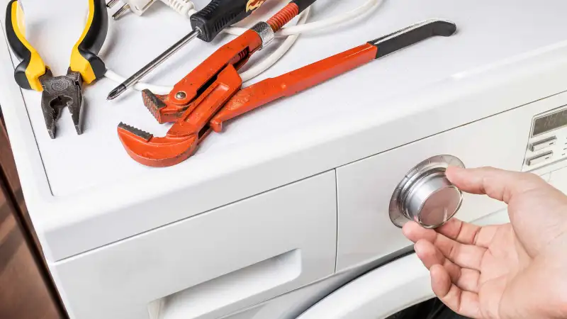 Photo of a person fixing a washing machine