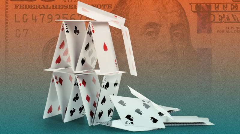 Photo collage of a falling house of cards with a hundred dollar bill in the background