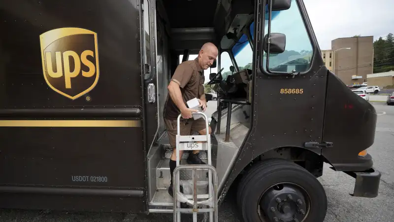 UPS delivery worker descending a UPS truck