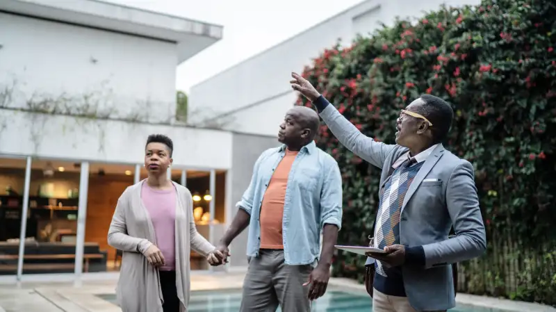 Real estate agent showing a couple a house for sale
