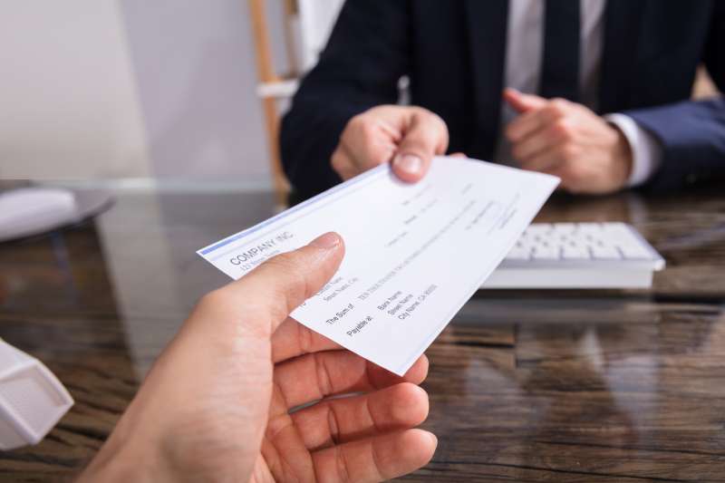 Person handing over a business check