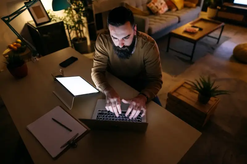 Man looking into his laptop with a serious look