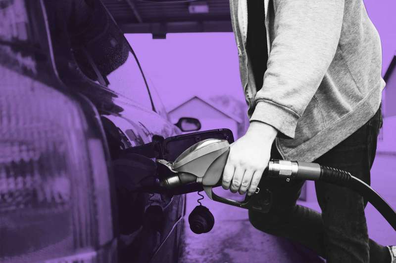 Midsection of a person refueling car at gas station