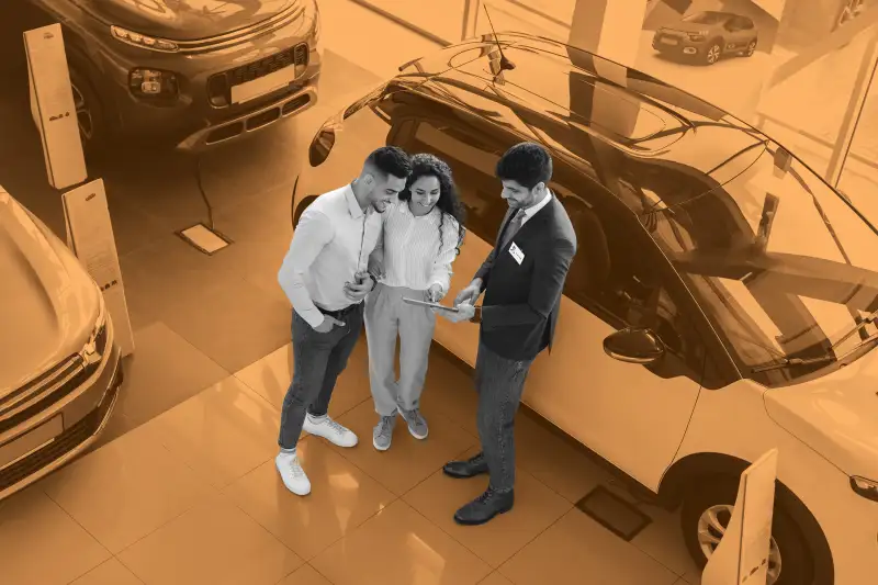 Customers having conversation with sales assistant, buying car, view above