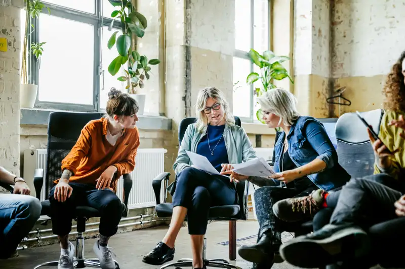 Three casual business women discussing during meeting