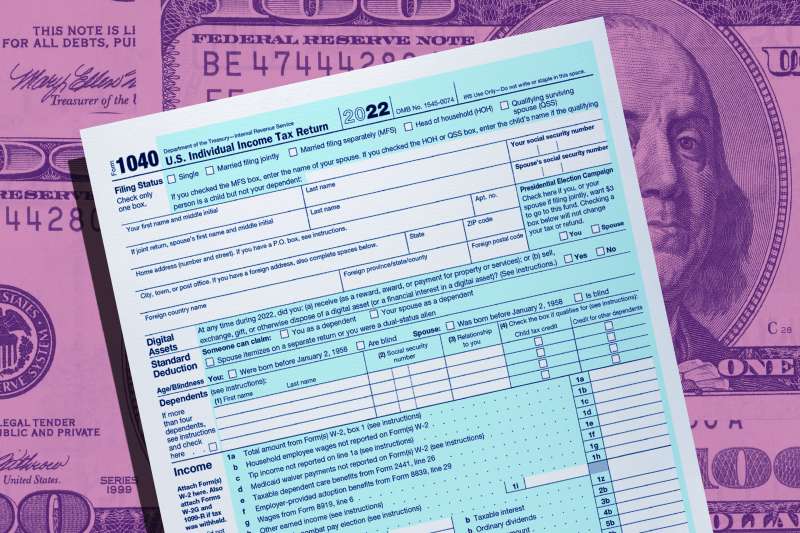 Photo collage of a 1040 Tax form with hundred dollar bills in the background