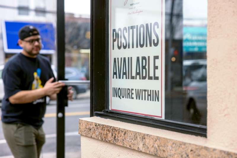 A Help Wanted sign seeking workers is on a window in Port Washington, New York