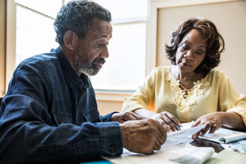 Senior couple paying bills at home