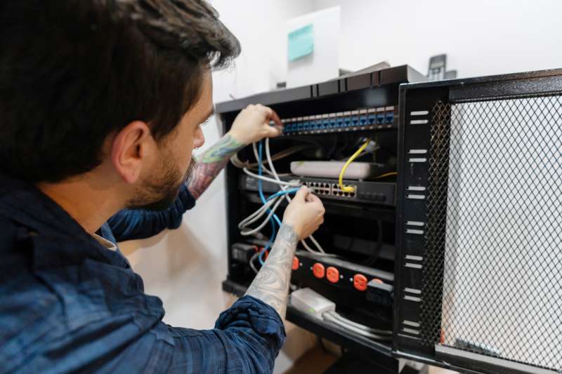 IT technician connecting cables of a a server at the office
