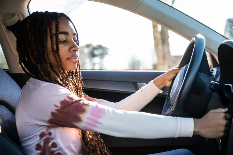 Portrait of teenage girl in her first car