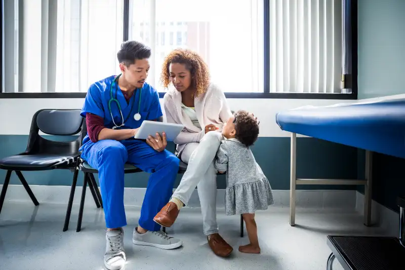 Male nurse explaining to a patient with kid