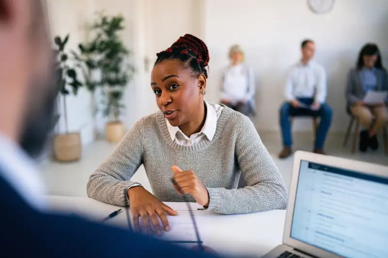 Woman talking during a job interview with her resume on hand