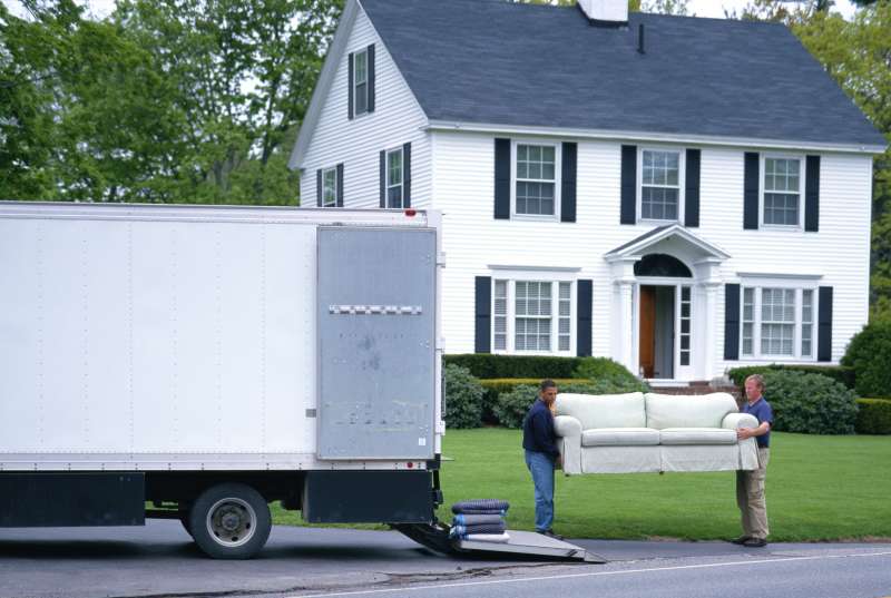 MOVING MEN UNLOAD FURNITURE FROM TRUCK