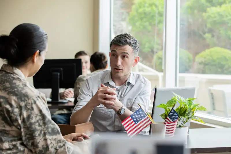 Mature financial planner meeting with a military solider.