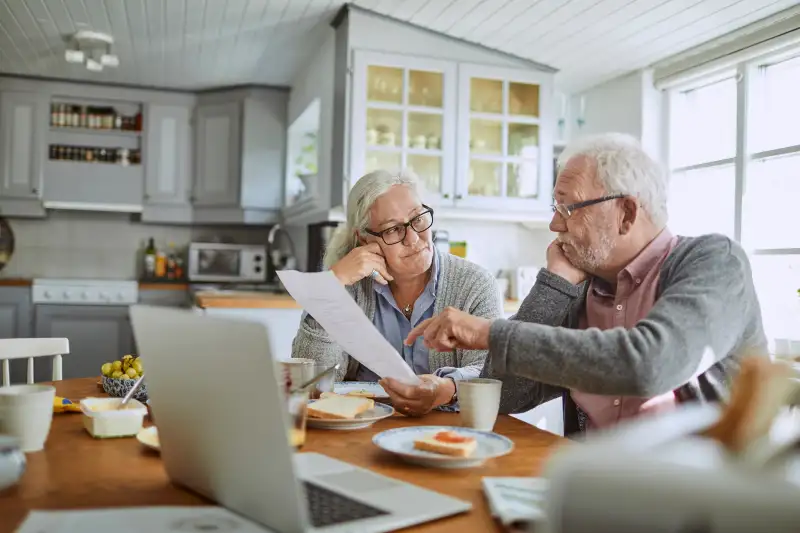 Senior couple having breakfast and doing bills