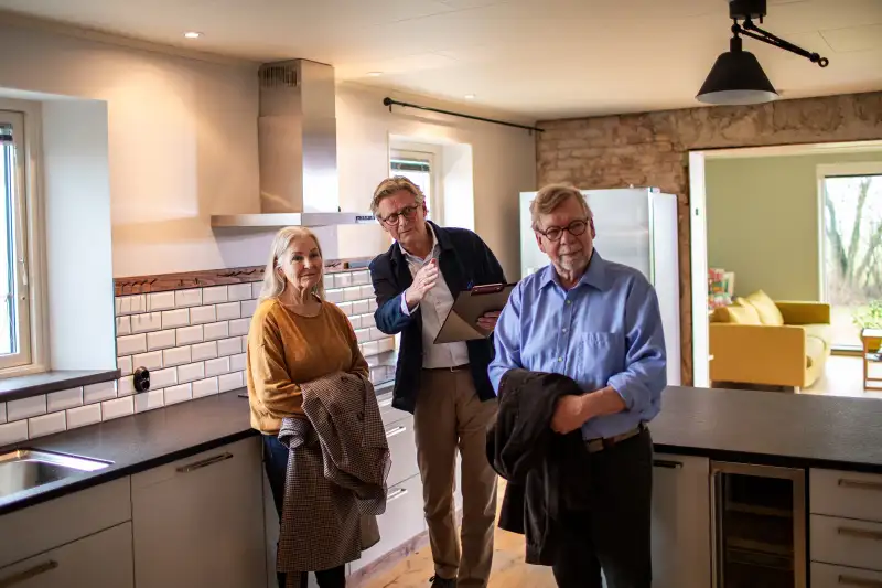 Senior real estate agent showing a house to a senior couple