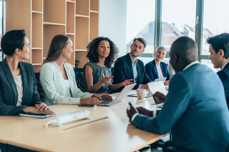 Multiethnic group of businesspeople sitting together and having a meeting in the office.