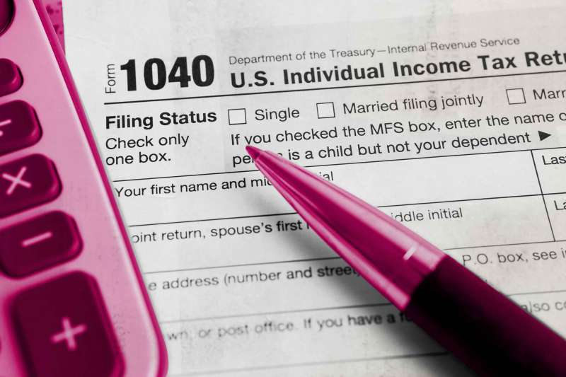 Tax Return form 1040 with USA America flag and dollar banknote, U.S. Individual Income.