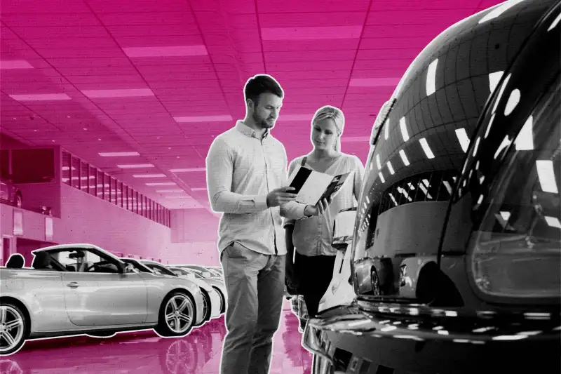 Couple looking at brochure in car showroom