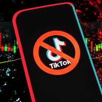 TikTok app logo crossed out with red ban sign displayed on phone screen over textured background with stocks graphics