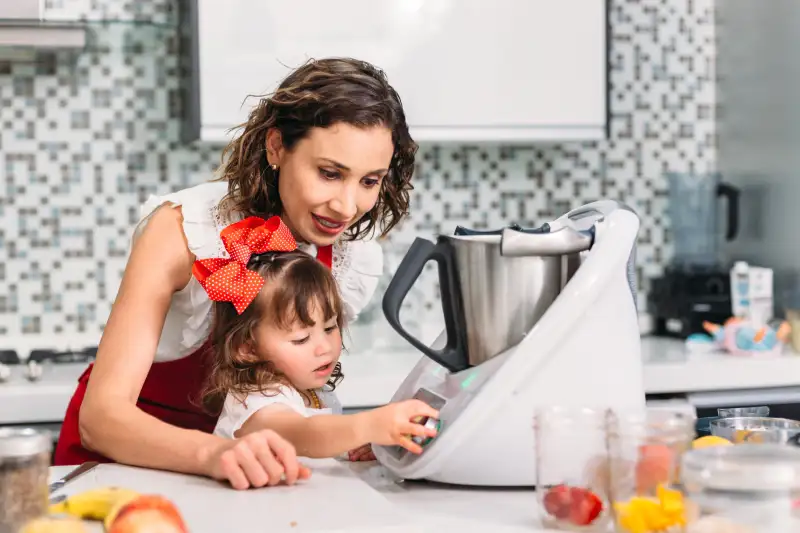 Mother and daughter cooking together in the kitchen