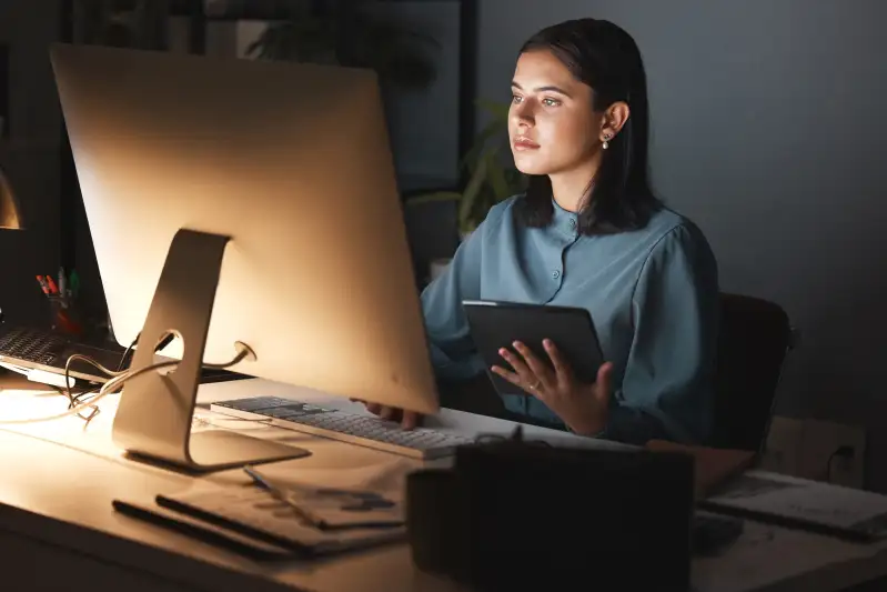 Woman using a digital tablet and a computer